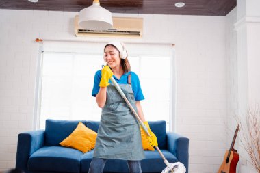 Happy Housework ya da ev hizmetçisi kadın şarkı söyleyip tozları temizliyor, küçük işletmeleri temizliyor. profesyonel ekipman eski evi temizliyor.