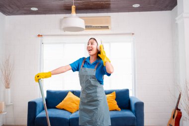 Happy Housework ya da ev hizmetçisi kadın şarkı söyleyip tozları temizliyor, küçük işletmeleri temizliyor. profesyonel ekipman eski evi temizliyor.