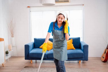 Happy Housework ya da ev hizmetçisi kadın şarkı söyleyip tozları temizliyor, küçük işletmeleri temizliyor. profesyonel ekipman eski evi temizliyor.