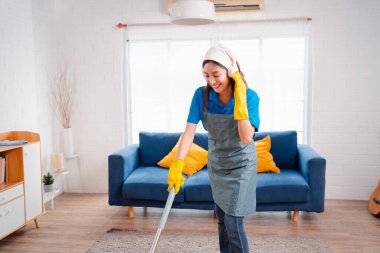 Happy Housework ya da ev hizmetçisi kadın şarkı söyleyip tozları temizliyor, küçük işletmeleri temizliyor. profesyonel ekipman eski evi temizliyor.