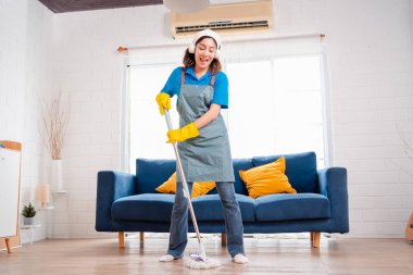 Happy Housework ya da ev hizmetçisi kadın şarkı söyleyip tozları temizliyor, küçük işletmeleri temizliyor. profesyonel ekipman eski evi temizliyor.