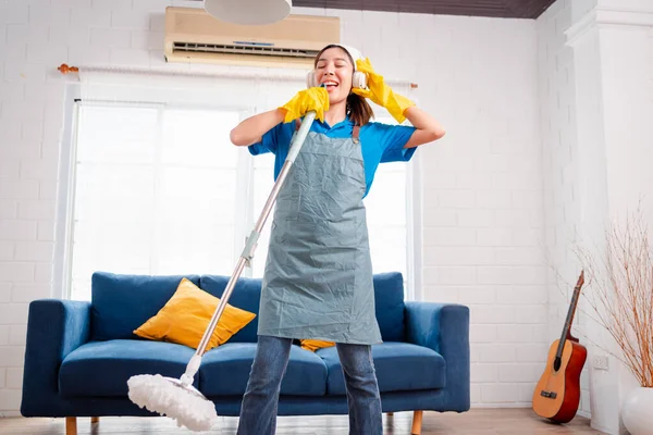 Happy Housework ya da ev hizmetçisi kadın şarkı söyleyip tozları temizliyor, küçük işletmeleri temizliyor. profesyonel ekipman eski evi temizliyor.