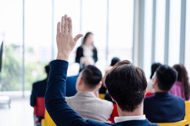 Seminer sırasında iş adamı elini kaldırıyor. Toplantı odasında ve seminer sınıfında bir soruyu cevaplamak için konferansta el kaldırın..