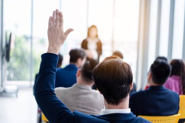 Seminer sırasında iş adamı elini kaldırıyor. Toplantı odasında ve seminer sınıfında bir soruyu cevaplamak için konferansta el kaldırın..