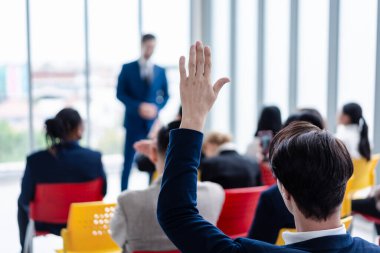 Seminer sırasında iş adamı elini kaldırıyor. Toplantı odasında ve seminer sınıfında bir soruyu cevaplamak için konferansta el kaldırın..