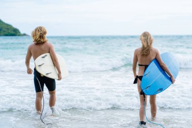 Hafta sonu sahilde sörf yapan çift, aşırı sağlıklı yaşam tarzı konsepti..