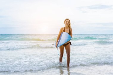 Haftasonu sahilde sörf yapan bir kadın, aşırı sağlıklı yaşam tarzı konsepti..