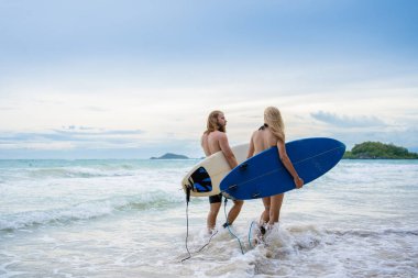 Hafta sonu sahilde sörf yapan çift, aşırı sağlıklı yaşam tarzı konsepti..