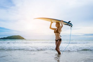 Haftasonu sahilde sörf yapan bir kadın, aşırı sağlıklı yaşam tarzı konsepti..