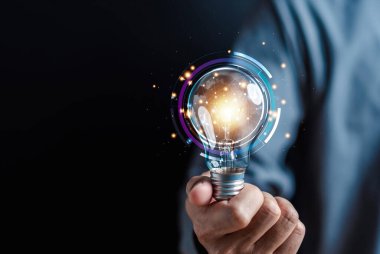 Elindeki ampul, fikir, yenilik ve ilham, parlayan sanal beyin, ampullerle akıllı yaratıcılık, motivasyon ve yenilik kavramı..