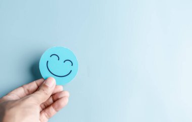 Tıbbi bakım konsepti için gülen surat tutan eller. zihinsel sağlık olumlu düşünce.