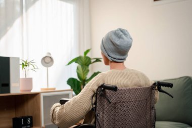 Genç bir kadın kanser hastası. Endişesi ve stresi var. Oturma odasında yaşam tarzını hissediyor..