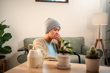 Genç bir kadın kanser hastası. Endişesi ve stresi var. Oturma odasında yaşam tarzını hissediyor..