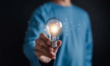 İş adamı zihin, yaratıcı, fikir, yenilik, motivasyon planlama geliştirme liderliği ve müşteri hedef grup kavramı için ampul tutuyor.