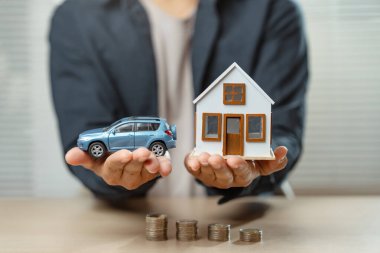 Sigorta acentesi sigorta ve araba tanıtımı ve satışı için imza atıyor. Erkek ajans sigortası ev ve araba alım satımında para hesaplar.