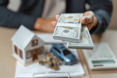 Sigorta acentesi sigorta ve araba tanıtımı ve satışı için imza atıyor. Erkek ajans sigortası ev ve araba alım satımında para hesaplar.