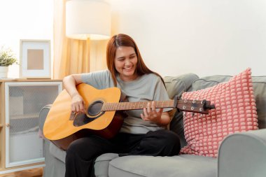 Asya 'lı Kadın Müzik Çalıyor Gitar Yaşamı Gevşeme Ders Rahatlaması, Gitar Çalışmasının Neşeli Anı, Sıcak Oturma Odasında Akustik ile Keyif ve Müzik Paylaşım