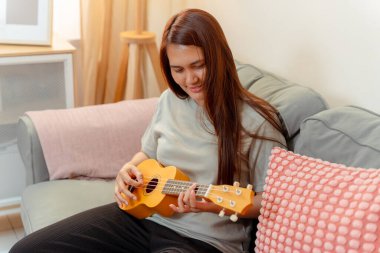 Asyalı Kadın Ukulele Müzik Çalıyor Ukulele Yaşam Tarzı Rahatlama Dersi Rahatlama, Neşeli Ukulele Uygulaması, Keyif ve Müzik Paylaşım Akustik ile Samimi Oturma Odası