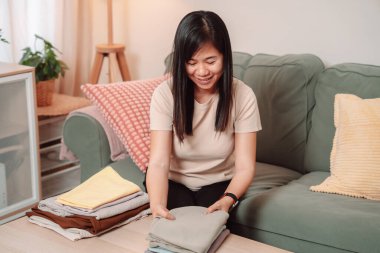 Kadın Katlanmış Yığın Kıyafetler Ev İşi Kadın Çamaşırı Yaşam Tarzı, Katlanan Taze Yıkanmış Giysileri Temiz Bir Yığına Çevirir, Evde Gülümseyerek Konforlu Bir Ev Hayatını Kucaklar