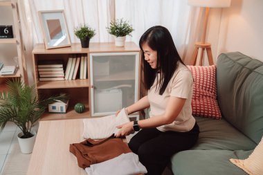 Kadın Katlanmış Yığın Kıyafetler Ev İşi Kadın Çamaşırı Yaşam Tarzı, Katlanan Taze Yıkanmış Giysileri Temiz Bir Yığına Çevirir, Evde Gülümseyerek Konforlu Bir Ev Hayatını Kucaklar