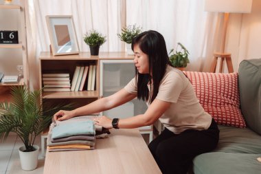 Kadın Katlanmış Yığın Kıyafetler Ev İşi Kadın Çamaşırı Yaşam Tarzı, Katlanan Taze Yıkanmış Giysileri Temiz Bir Yığına Çevirir, Evde Gülümseyerek Konforlu Bir Ev Hayatını Kucaklar