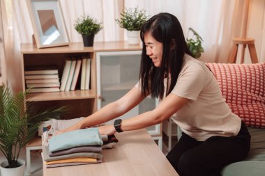 Kadın Katlanmış Yığın Kıyafetler Ev İşi Kadın Çamaşırı Yaşam Tarzı, Katlanan Taze Yıkanmış Giysileri Temiz Bir Yığına Çevirir, Evde Gülümseyerek Konforlu Bir Ev Hayatını Kucaklar