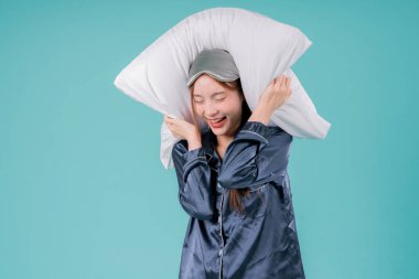 Asyalı kadın kulaklarında yastıkla uyuyor, gürültüden bitap düşmüş.