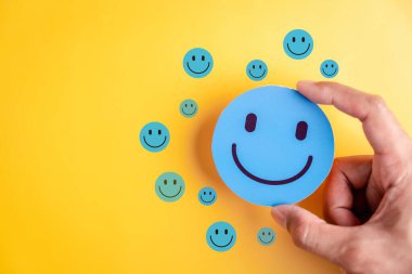 Pozitif duygu ve akıl sağlığı. Gülen surat çoklu mutlulukla çevrili. Sağlık, mutluluk, iyimserlik ve kendine dikkat için idealdir..