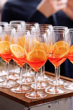 Bir bardak alkollü Aperol Spritz kokteyli. Partide buzlu, aperatifli İtalyan aperatifi, Prosecco, soda ve büyük yuvarlak bardaklarda bir dilim portakal. Kutlama kavramları şenlik günleri