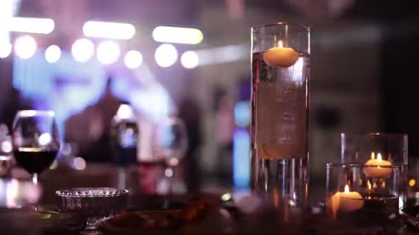 유리병에 촛불을 촛불을 파티에서 사람들이 춤추는 실루엣 디스코 탐조등을 비추며 — 비디오