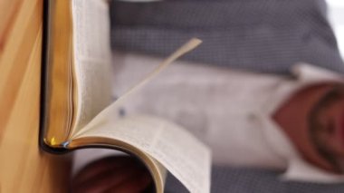 Tanınmayan bir adamın elleri sayfaları çeviriyor, ağır çekimde. Kitap okumak ve sayfaları çevirmek, kapat. Görünmez adam kitap ya da İncil okuyor ve sayfaları karıştırıyor. Kendi kendini eğitme