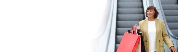 Баннер Стильная Улыбающаяся Взрослая Женщина Поднимается Эскалаторе Красочными Сумками Покупок — стоковое фото