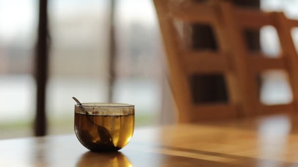 Szklana Przezroczysta Filiżanka Świeżo Parzonej Czarnej Herbaty Łyżeczką Drewnianym Stole — Wideo stockowe