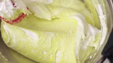 Pasta şefi silikon spatulasını Fransız çöl Makaronu ya da Makarnası için sarı hamuru paslanmaz çelik bir kasede hazırlar. Pasta ya da pastane kavramı ya da pastane.