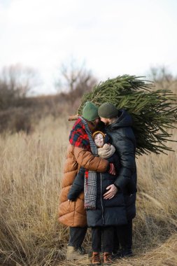 Genç baba, anne ve kız Noel ağacını eve götürmek için tutuyorlar. Aileler birlikte eğleniyor ve yeni yıla hazırlanıyorlar. Evlerini ladin ve köknar ağacıyla süsleyecekler..