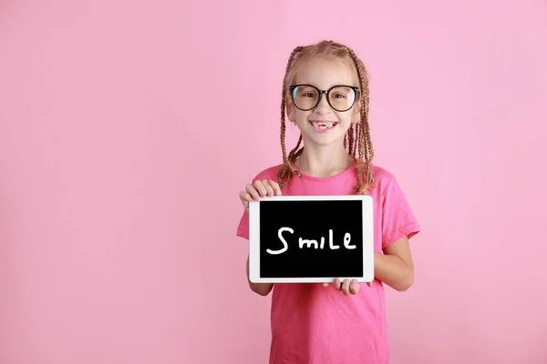Uśmiechnięta Urocza Dziewczynka Trzyma Tabliczkę Różowym Tle Biały Dzieciak Okularach — Zdjęcie stockowe