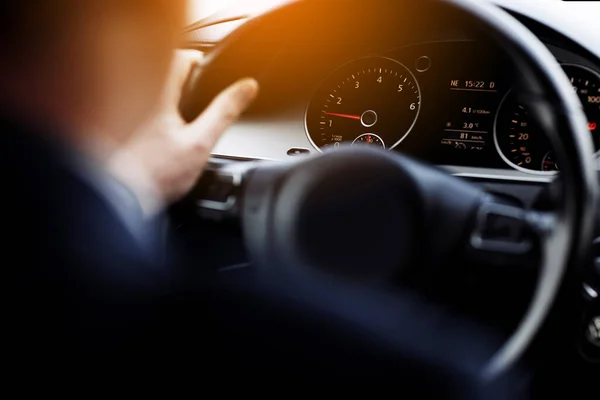 stock image Cropped photo of arms businessman hands in classic white shirt and gold watch driving car hold wheel in new modern automobile vehicle black luxury rich salon Sale technology lifestyle concept