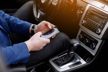 Proje istatistikleri, grafik ve diyagramı ile çalışan takım elbiseli işadamı, modern arabada otururken mali verileri analiz eden girişimci muhasebeci. Erkek, iş yerine arabayla gidiyor..