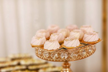 Altın tepside pembe kremalı tatlı. Çikolata. Şenlikli düğün tatlıları.