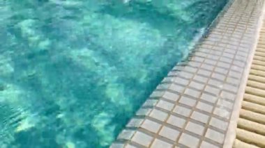 Water surface texture, clean swimming pool ripples and wave. Concept of summer trip, vacation or holiday in hotel or sport and recreation. Blue tiles on bottom