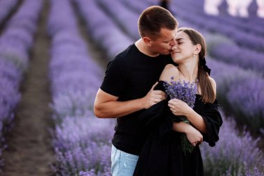 valentines day. loving couple hugging in purple lavender field at sunset. Beautiful young people have dating and walking together outdoor on summer warm day. Concept of love. young family of two.