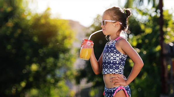Piękna Dziewczynka Uroczy Maluch Okularach Przeciwsłonecznych Pije Sok Pomarańczowy Pokazuje — Zdjęcie stockowe