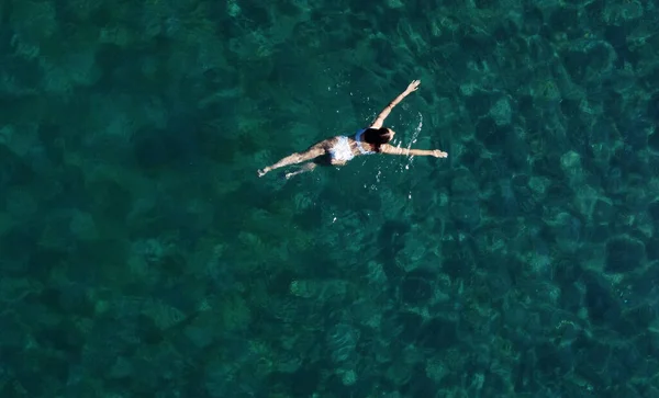 바다에서 수영하는 여성의 위에요 수영복을 소녀가 청록색 바다에서 물위를 떠다니는 — 스톡 사진