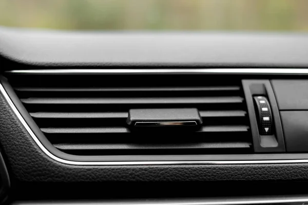 Air conditioner flow inside the car, plastic grid panel. Vehicle air conditioning close up view. Detail interior of modern car. Air ducts. Dashboard.