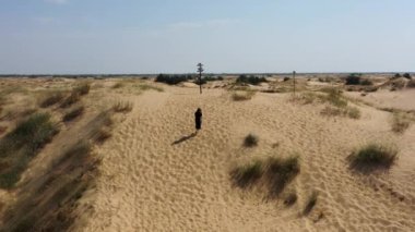 Avrupa 'nın en büyük çölünde, Ukrayna' da, Oleshky Sands 'de çalılar ve çam ağaçlarıyla yürüyüş yapan genç bir kadının hava aracı görüntüsü. Rusya 'nın Ukrayna' daki savaşından önce turizm alanında. işgal edilen bölge.