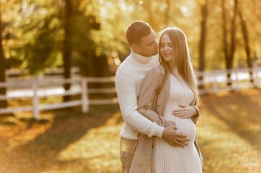 Genç ve şık çift aşıkları sonbahar parkında sarılıp öpüşüyorlar. Birbirine aşık bir kadın ve erkek arasında romantik bir an. Mutlu bir aile. Aşk, gençlik, mutluluk konsepti
