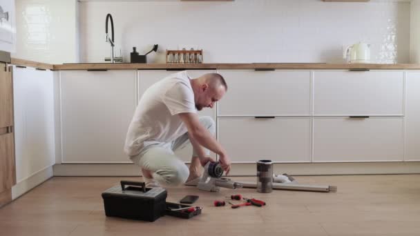 家事と技術の概念 自宅のキッチンフロアで 部品の修理 または交換を行う人 メンテナンスの概念 現代の家電製品 — ストック動画