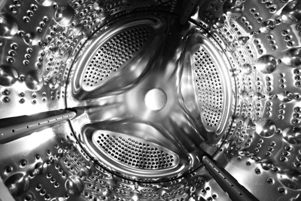 Inside of a shine steel drum of the washing or dryer machine. Laundry day. Daily household chores. Domestic and household appliance. Home innovation