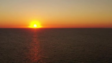 Deniz yüzeyinde uçan hava aracı günbatımının ya da deniz suyunda güneşin doğuşunun turuncu yansımalarıyla. Sabahları tropik manzara. Rahat ol. Doğa ve yaz tatili konsepti. 4k.