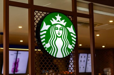 Valencia, Spain: March 18, 2023: Trademark green logo Starbucks with two-tailed mermaid siren inside coffeeshop. Starbucks Corporation is multinational chain of coffeehouses and roastery reserves. clipart